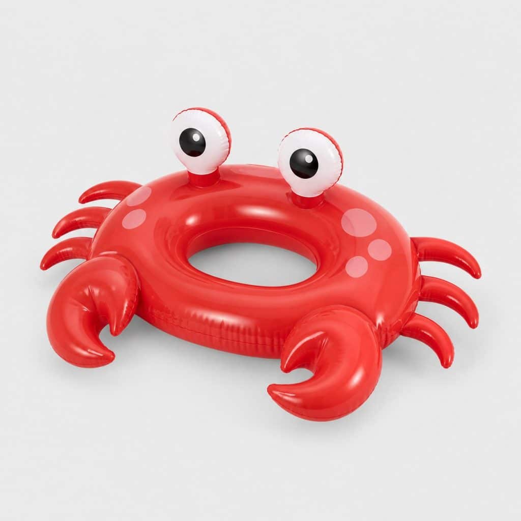 Bouée rouge en forme de crabe flottant à la surface d'une piscine