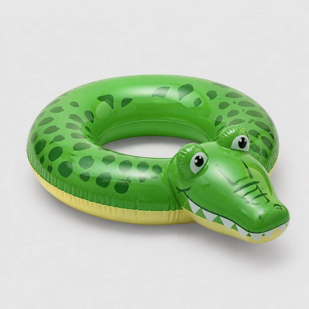 Bouée ronde verte en forme de crocodile flottant à la surface d'une piscine