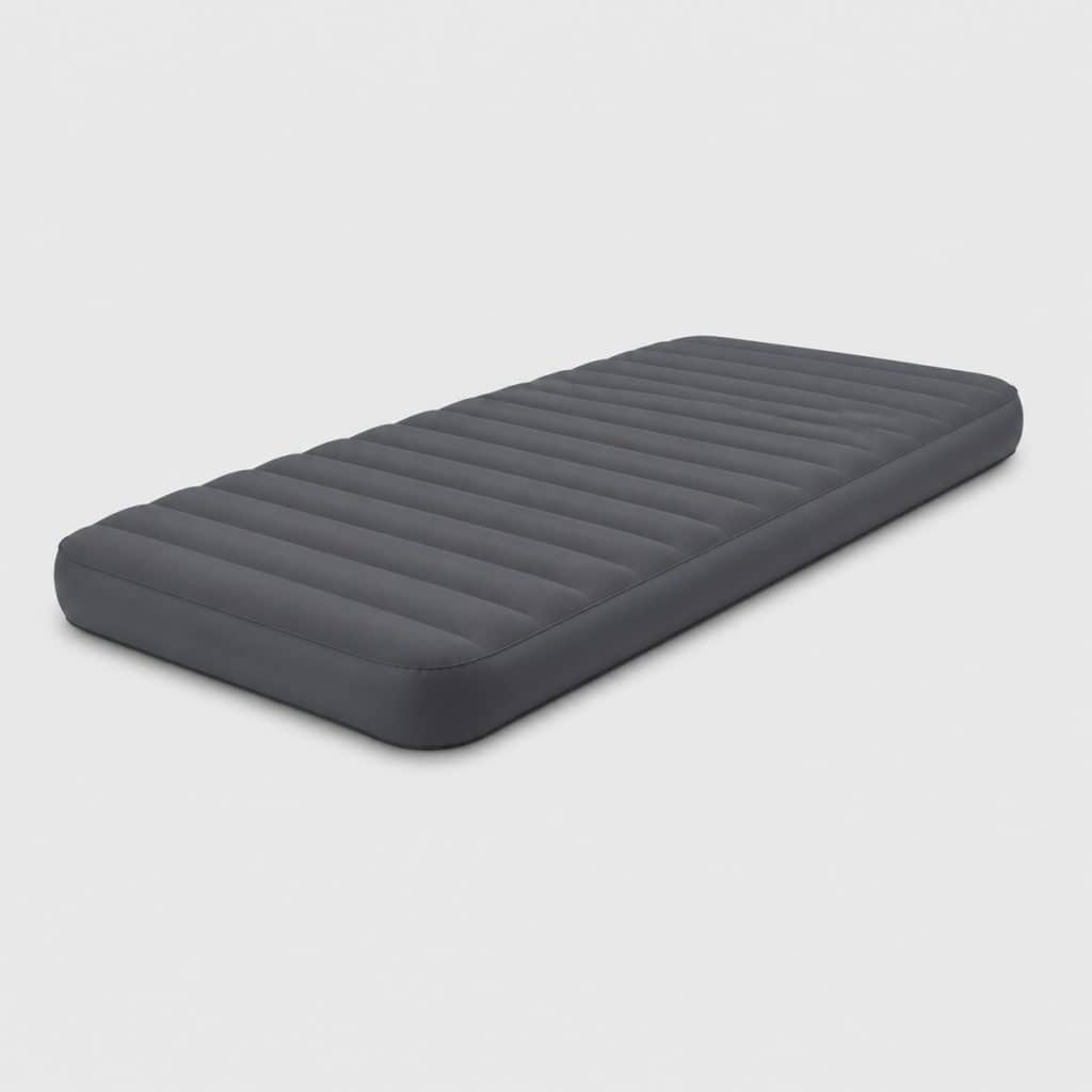 Matelas de couchage gonflable gris déployé dans une tente