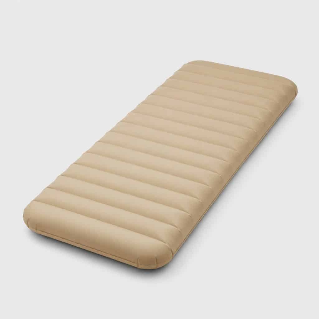 Matelas gonflable beige flottant à la surface d'une piscine