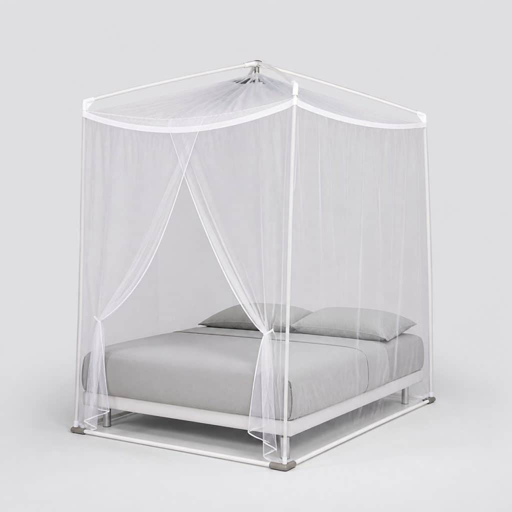 Support blanc posé au sol tenant une moustiquaire autour d'un lit